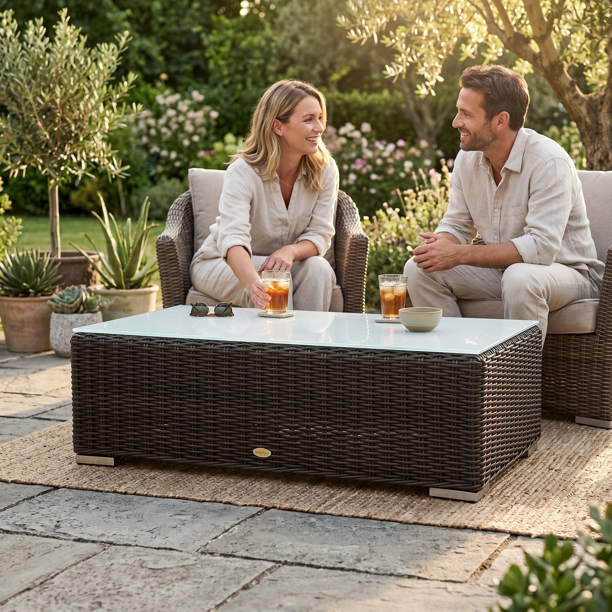 Maui Rattan Lounge mit Glasplatte für Outdoor im Garten auf einer Terrasse.