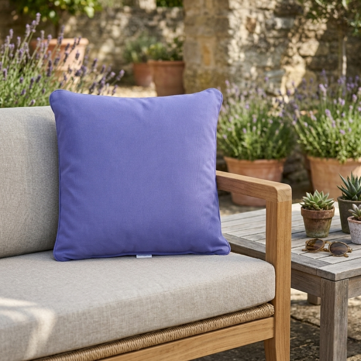 Violettes Zierkissen für den Outdoor-Gartenbereich auf einer Holzbank